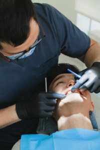 A patient getting his teeth checked by a dentist