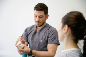 a dentist showing a teeth model to a patient