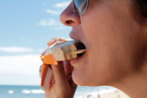 a person biting an ice cream bar