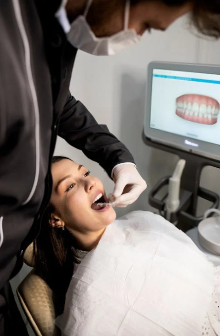 a dentist checking a woman’s teeth